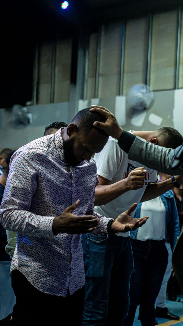 programs-03 Men engaged in a spiritual prayer gathering inside a worship venue, reflecting devotion.