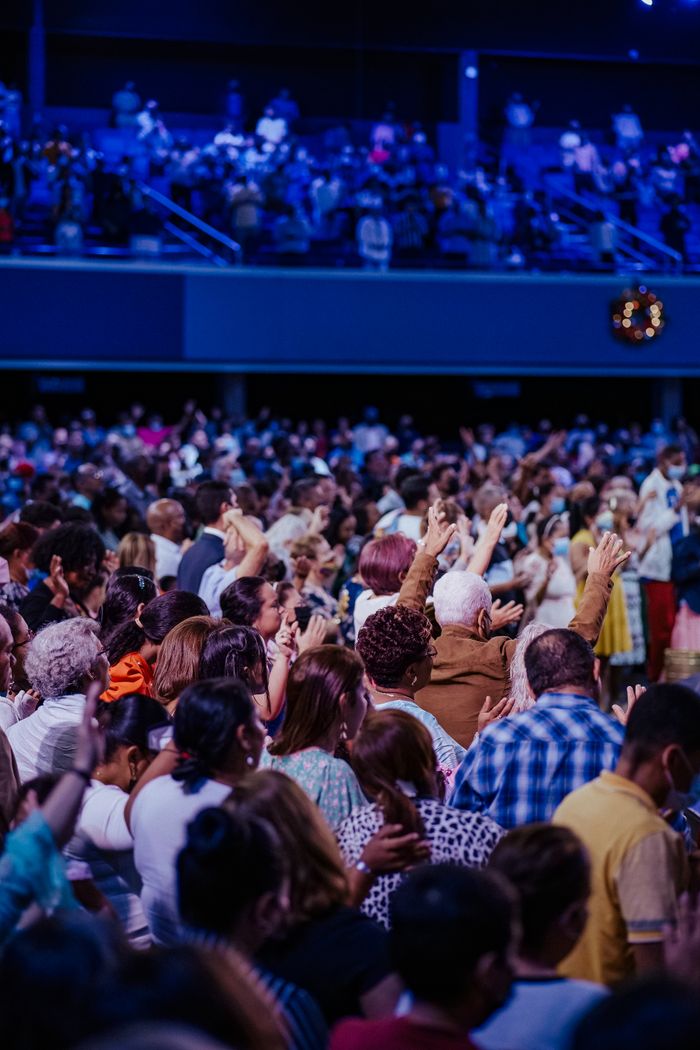 cta-01 A large congregation engaged in worship inside a vibrant spiritual setting.