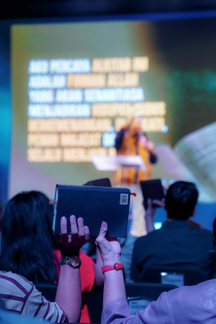 programs-01 Attendees raise Bibles at a vibrant worship event in Jakarta, Indonesia.