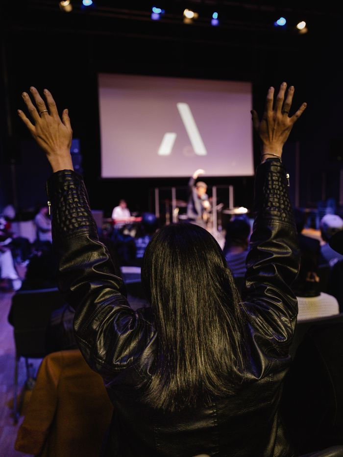 gallery-img-03 An enthusiastic worship gathering with people raising hands during a church service