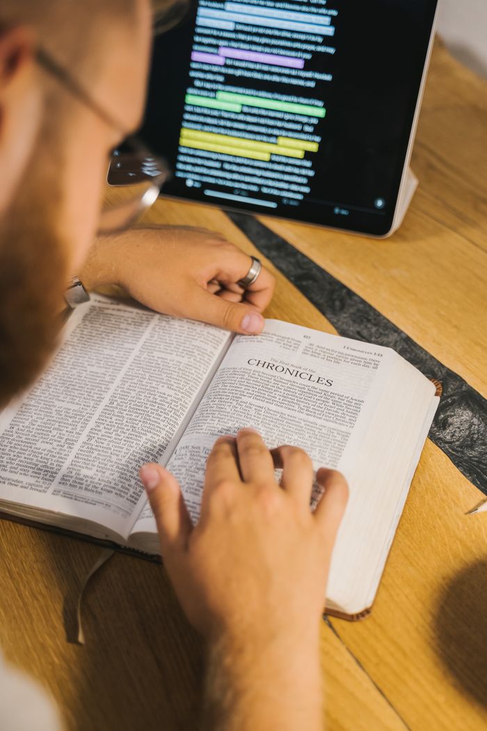 hero-gallery-02 An open Bible with Chronicles being studied, accompanied by a digital tablet for reference.